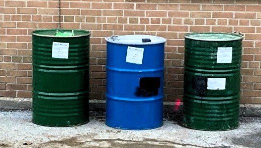 Three sealed drums labelled and ready for disposal